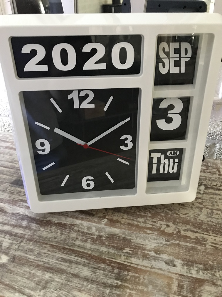 Een klok met jaar, datum en tijd, met standaard, maar kan ook aan de muur hangen, wit