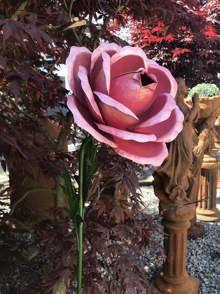 LETZTE: Ein Kunstwerk, große rosa Rose aus Metall, auf Stiel