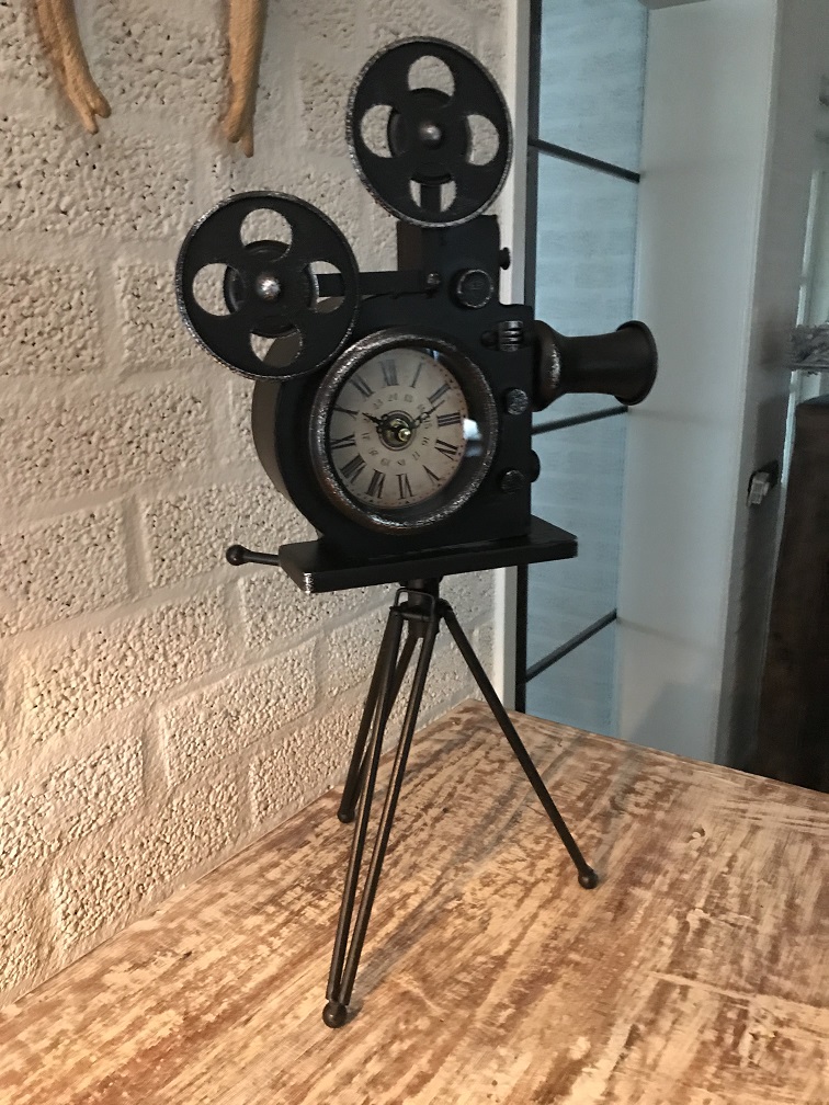 Een nostalgische en decoratieve klok in de vorm van een oude filmcamera