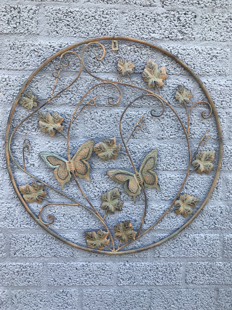 Een metalen wandornament met bladeren en vlinders, zeer decoratief!