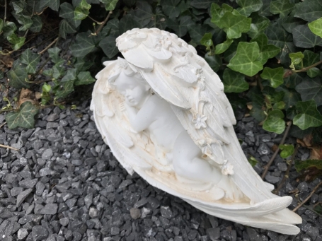 Statue of an angel sleeping in his wings, made of polystone