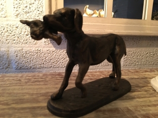 Hunting dog with prey in bronze-metal look.