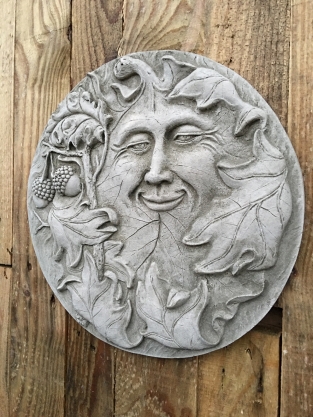 Wall ornament stone round, with an image of the cheerful oak leaf man, forest spirit.