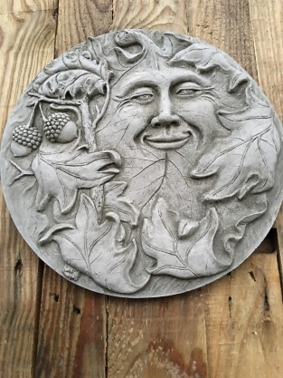 Wall ornament stone round, with an image of the cheerful oak leaf man, forest spirit.