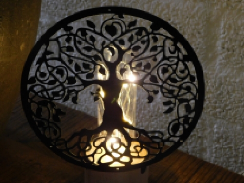 Hübsche Lampe mit einem ornamentalen Lebensbaum vor der Lampe.