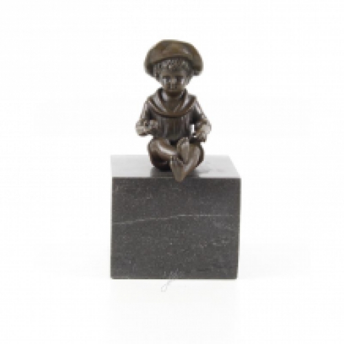 Eine Bronzeskulptur eines kleinen, sitzenden Jungen