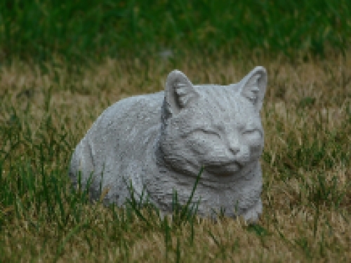 Statue of a lying cat - made entirely of stone - garden statue