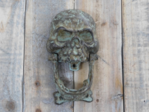 Cast iron green-brown skull as a door knocker.