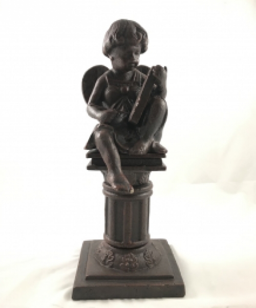 Intact statue of an angel sitting on a pedestal writing, cast iron