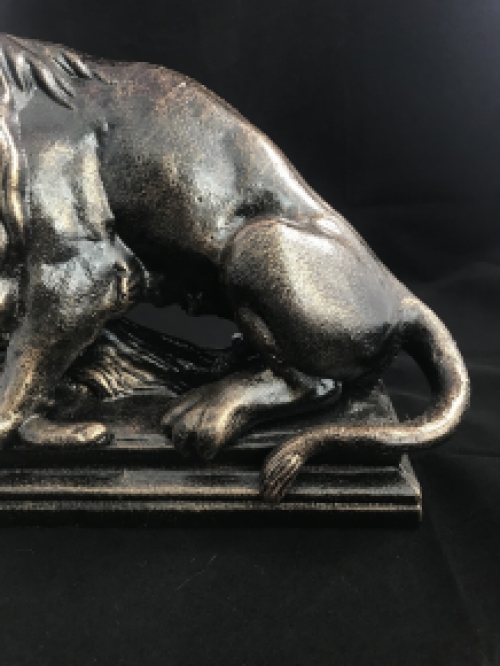 A beautiful statue of a lion with its prey, a boar, made of cast iron, bronze look!