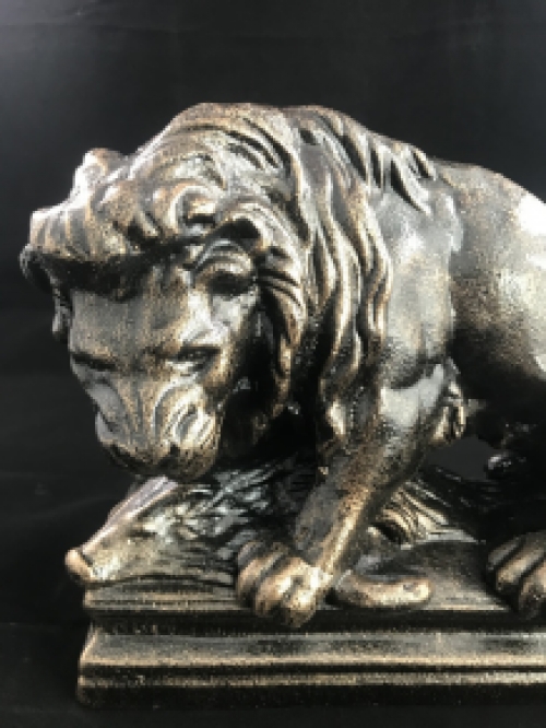 A beautiful statue of a lion with its prey, a boar, made of cast iron, bronze look!