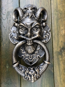 Cast iron bronze door knocker with devil's head.