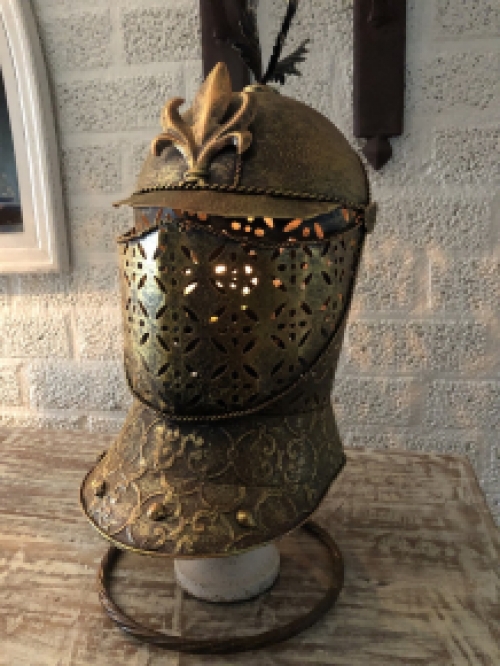 A beautiful metal brass knight helmet on stand.