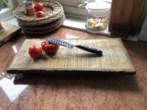 Beautiful rustic cutting board made of solid wood, nostalgic kitchen board, with metal brackets.