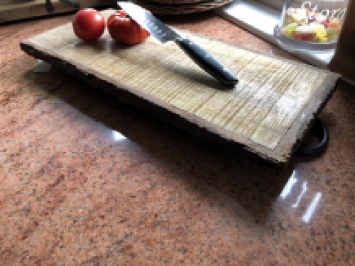 Beautiful rustic cutting board made of solid wood, nostalgic kitchen board, with metal brackets.