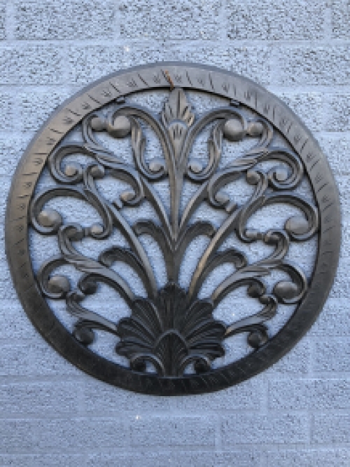 Wall ornament round, decoratively carved, black-brown.