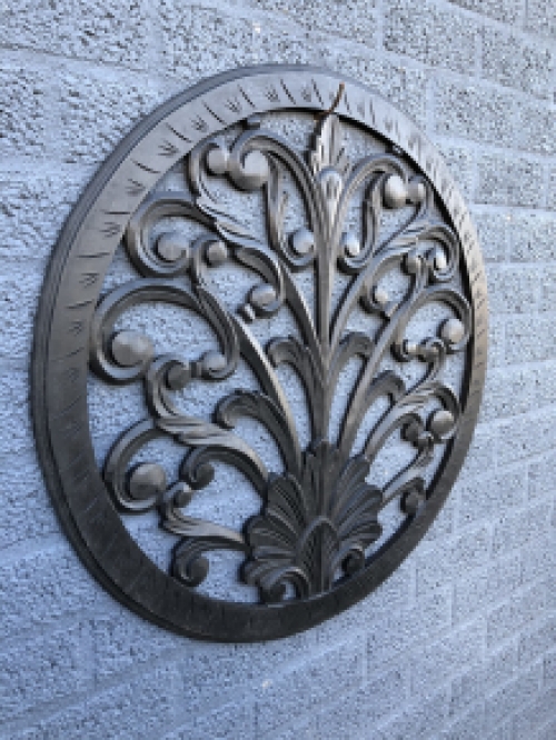 Wall ornament round, decoratively carved, black-brown.