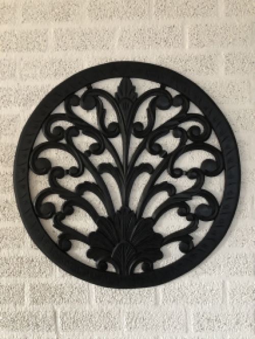 Wall ornament round, decoratively carved, black-brown.
