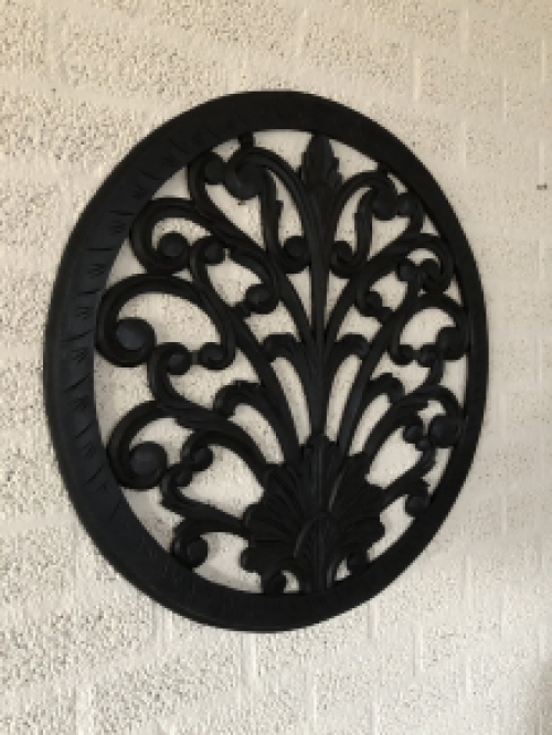 Wall ornament round, decoratively carved, black-brown.