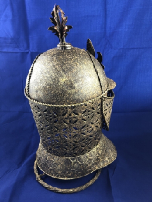 A beautiful metal brass knight helmet on stand.