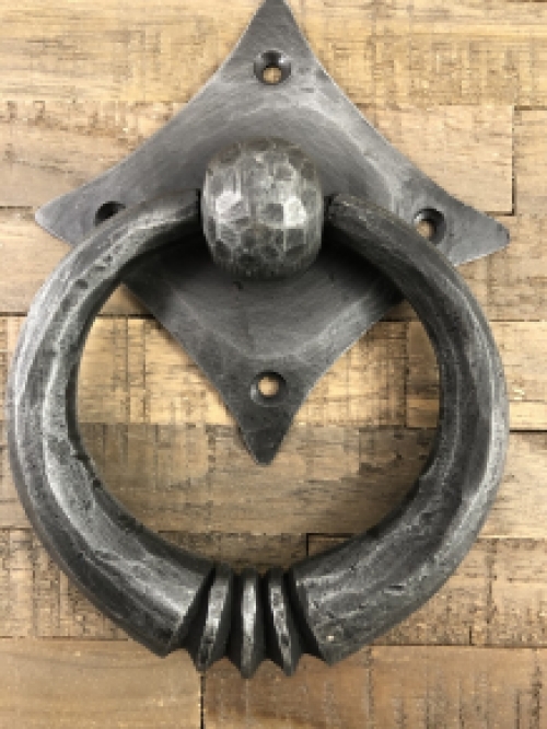 Pull-ring - door knocker wrought iron for on the rustic wooden door, convent door, country house door.