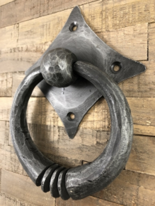 Pull-ring - door knocker wrought iron for on the rustic wooden door, convent door, country house door.
