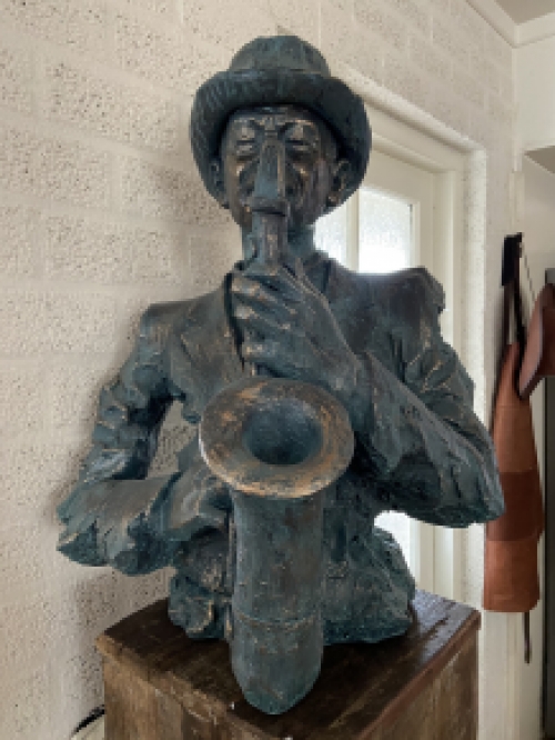 Beautiful torso of a jazz musician with saxophone in green-gold