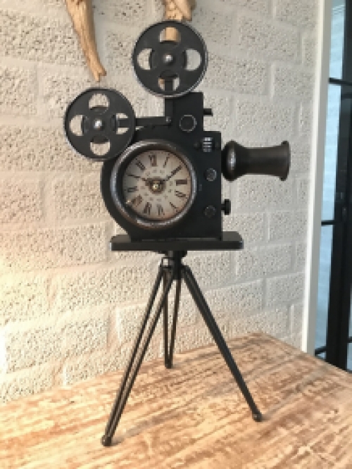 Een nostalgische en decoratieve klok in de vorm van een oude filmcamera