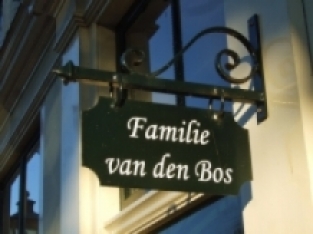 Winkel naamschild voor in de oude binnenstad, reclame teken gemaakt van metaal, ovaal,  groen geschilderd.