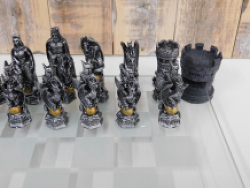 A chess game with the theme: ''knight-dragons'', beautiful chess pieces like medieval knights on glass chessboard with rooks.