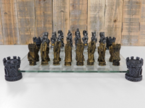 A chess game with the theme: ''knight-dragons'', beautiful chess pieces like medieval knights on glass chessboard with rooks.