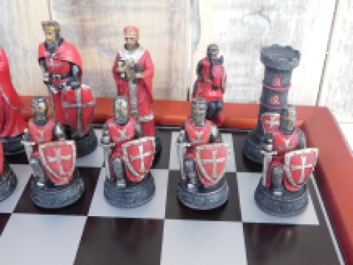 A chess game with the theme: ''MEDIEVAL KNIGHTS'', beautiful chess pieces like medieval knights on a wooden chessboard.