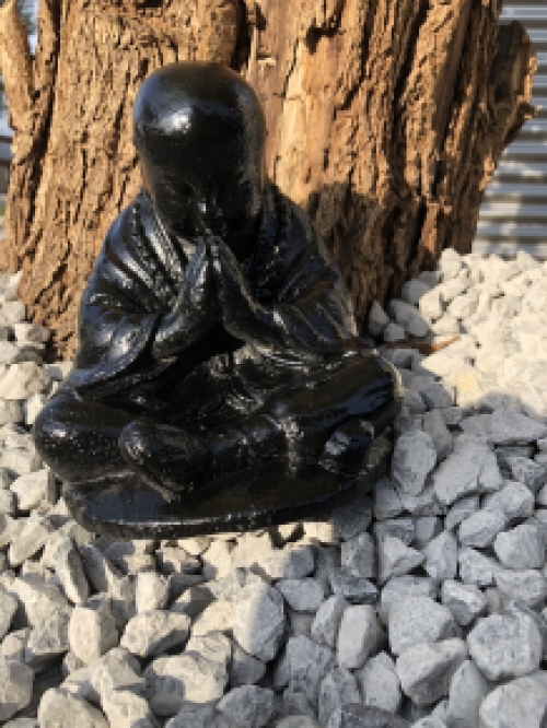 Shaolin Monk sitting praying, full of stone black