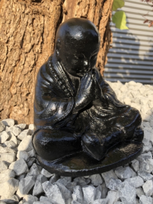 Shaolin Monk sitting praying, full of stone black