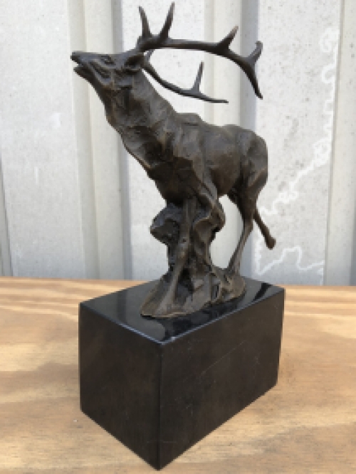 A bronze statue/sculpture of a deer