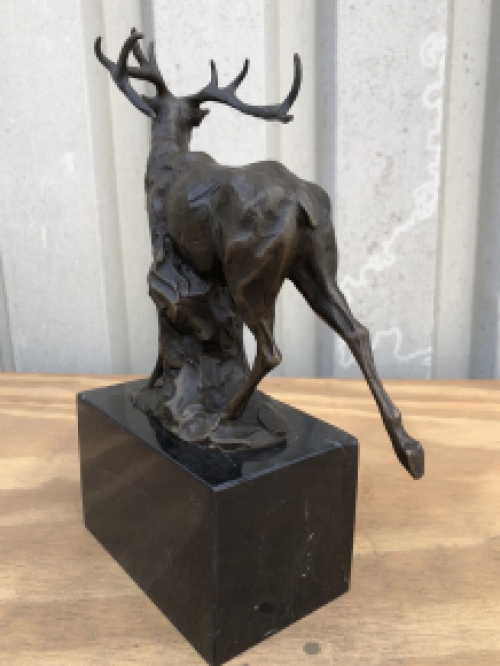 A bronze statue/sculpture of a deer