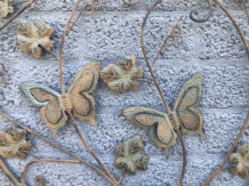 A metal wall ornament with leaves and butterflies, very decorative!