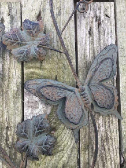 A metal wall ornament with leaves and butterflies, very decorative!