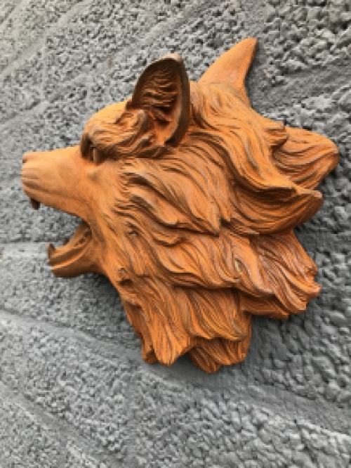 Wolvenkop, gietijzeren wandornament met een rustiek oppervlak